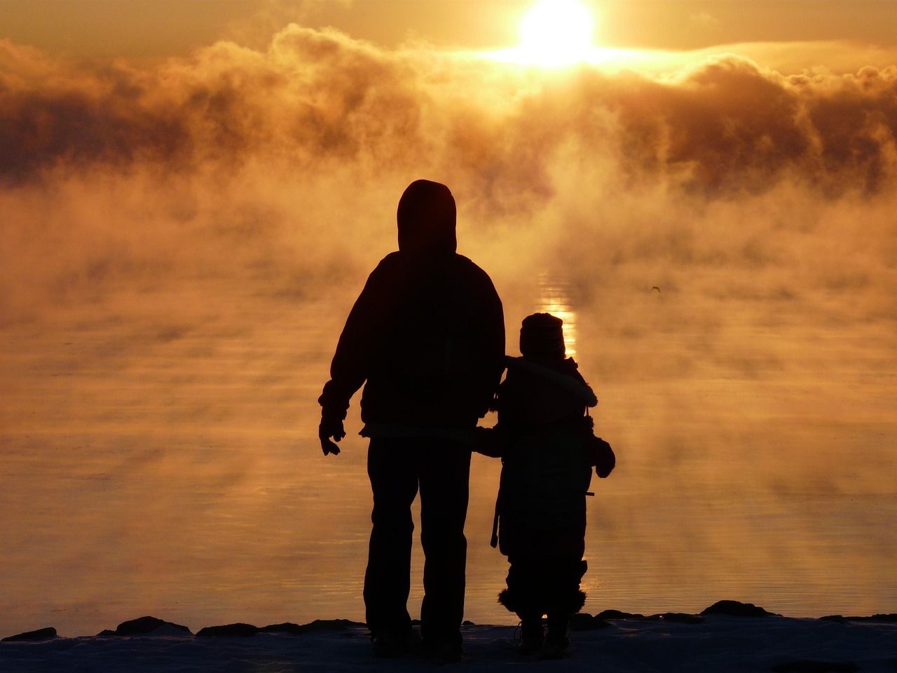 Silueta de familia al atardecer con luz dorada